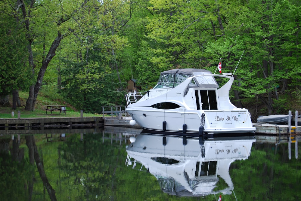 a white boat is docked at a dock