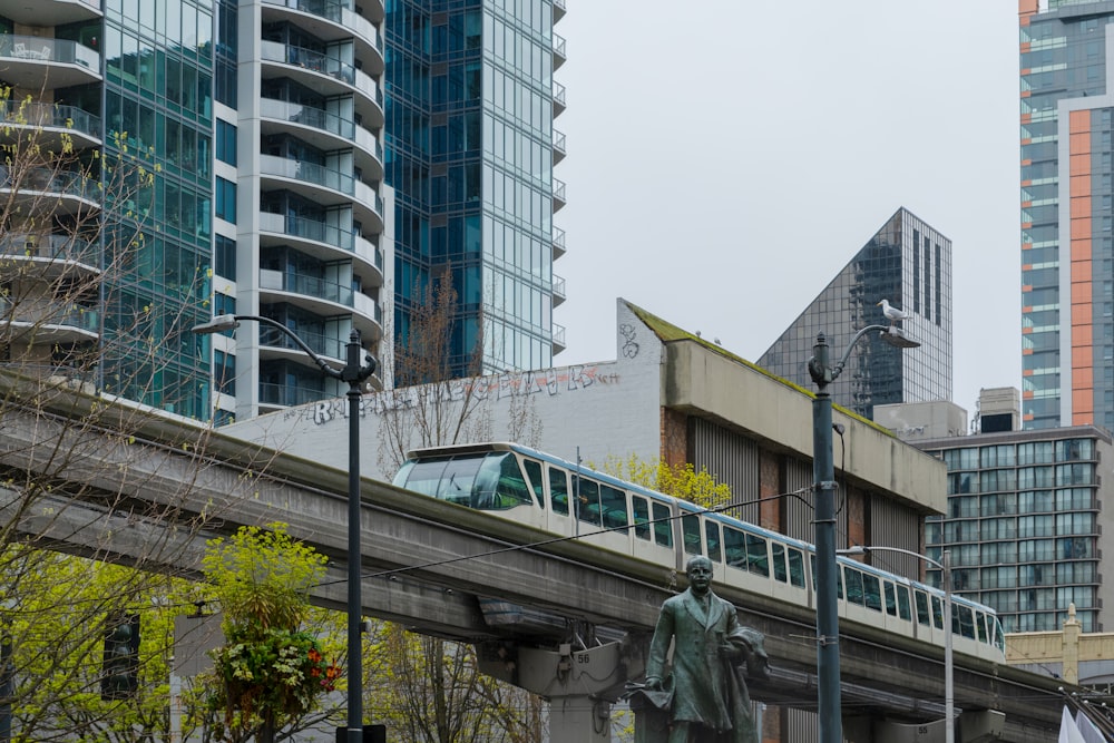 a train traveling over a bridge next to tall buildings