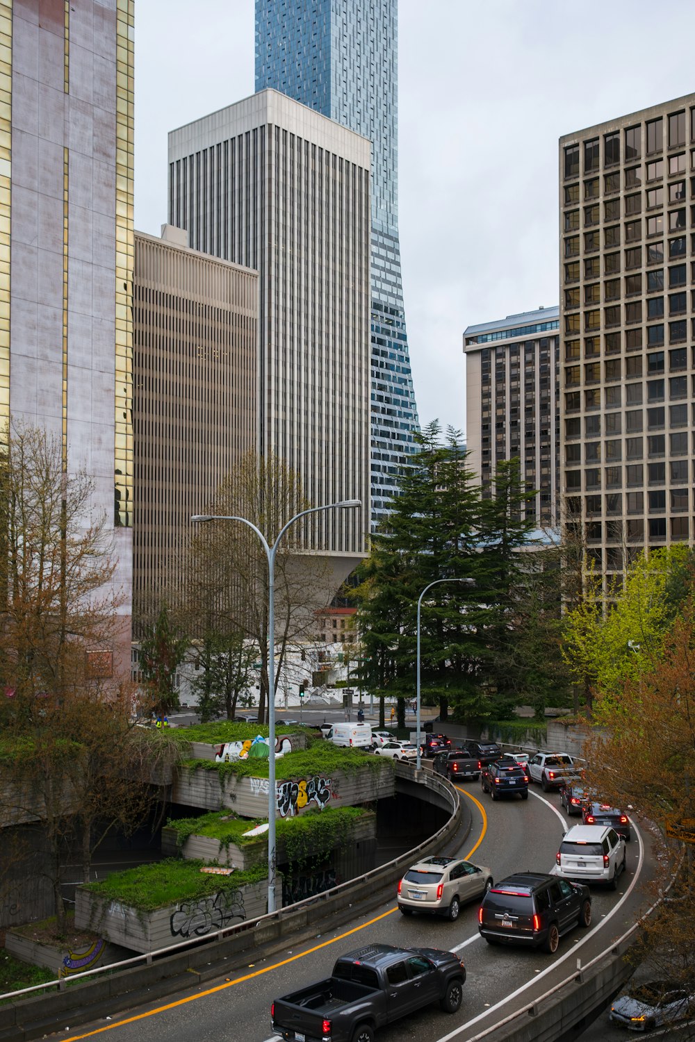 a city street filled with lots of traffic next to tall buildings