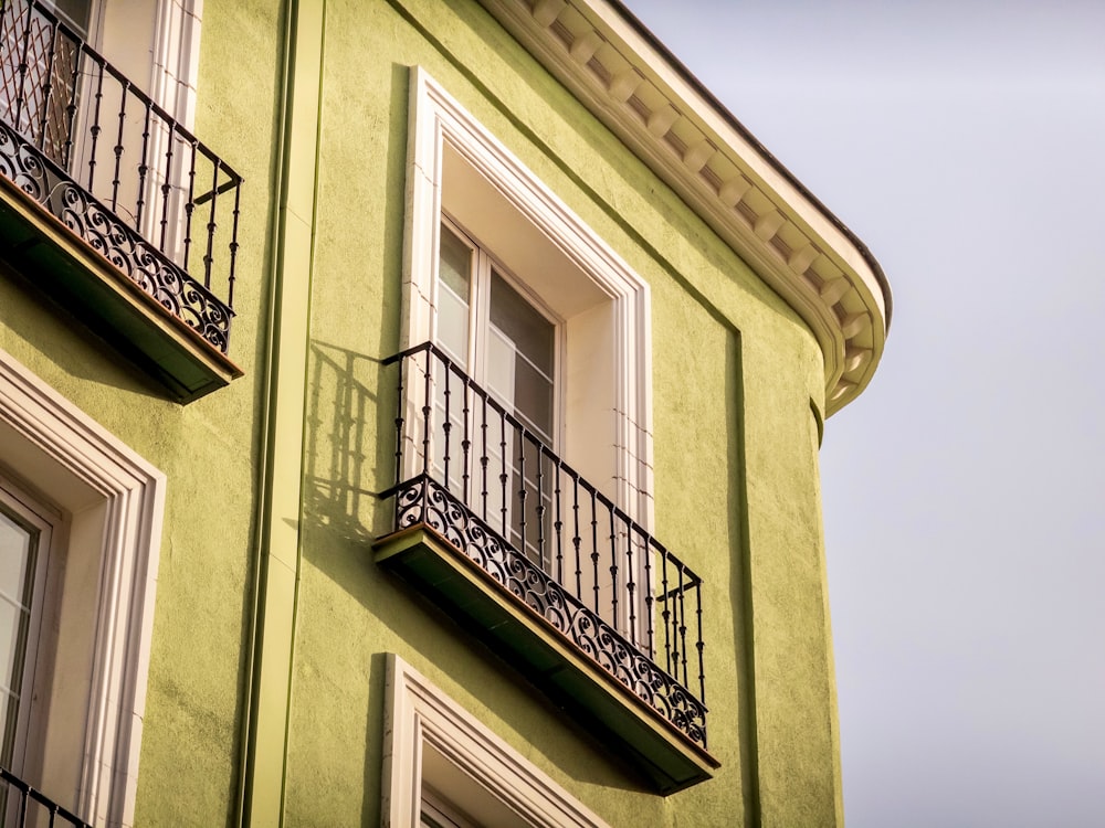 a green building with a balcony and balconies