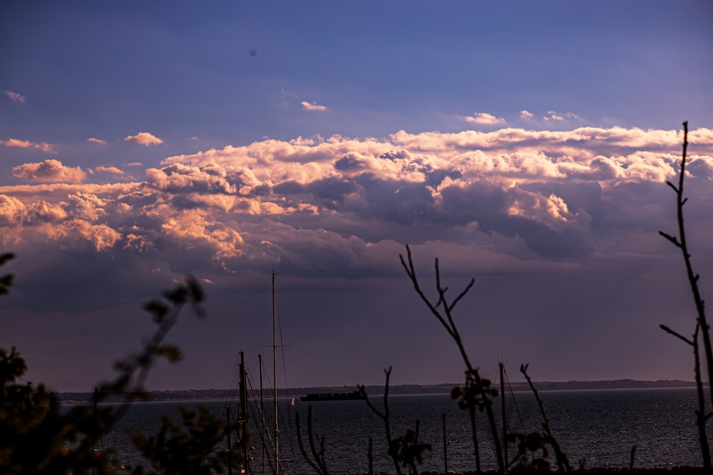 a view of a body of water with clouds in the background