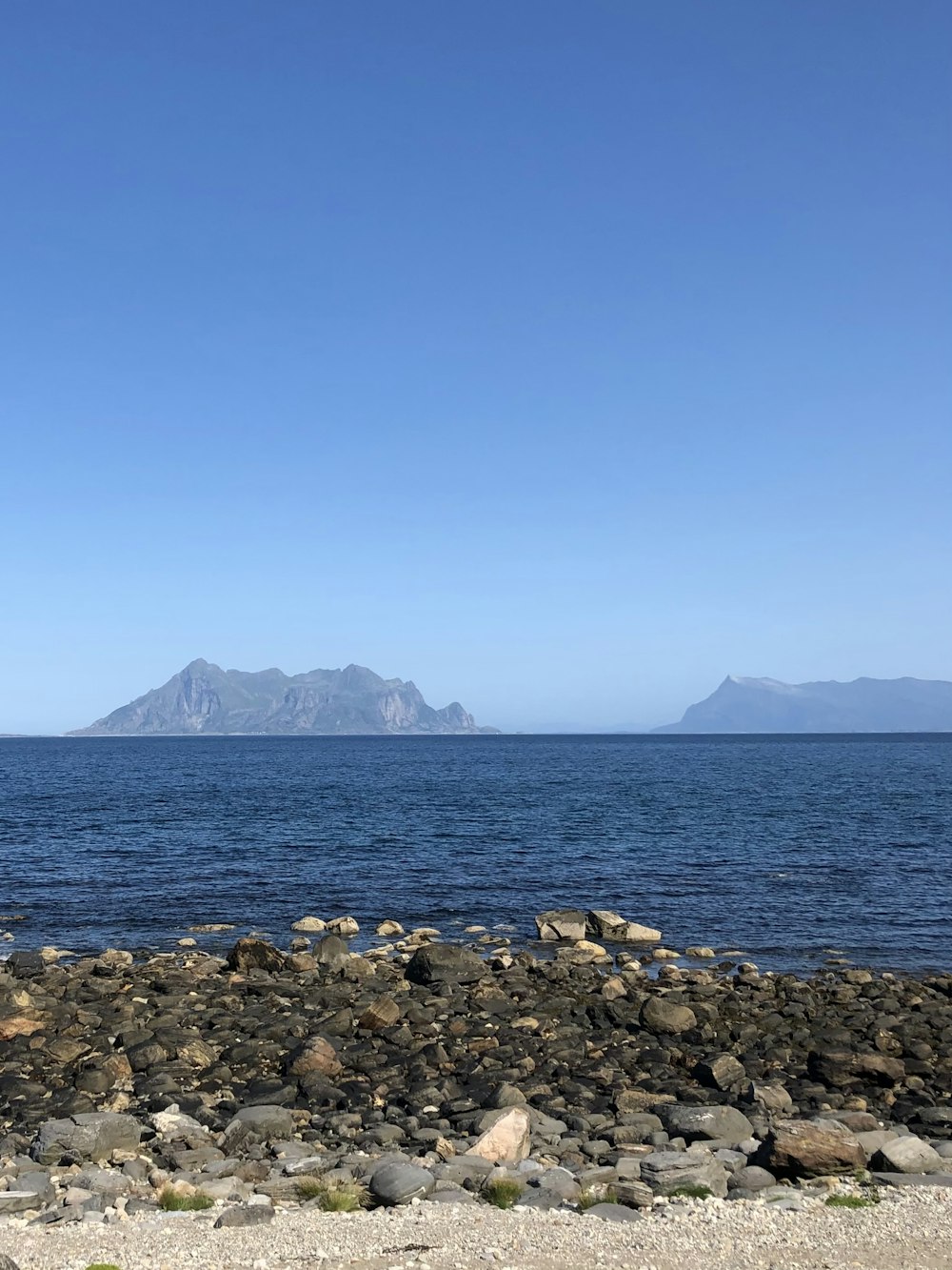 a bench sitting on the shore of a large body of water