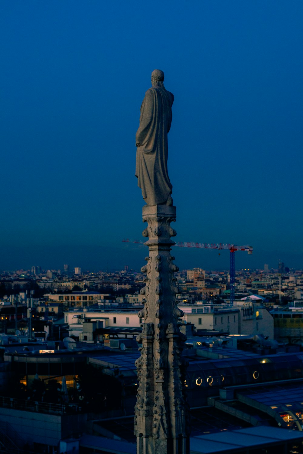 a statue on top of a building with a city in the background