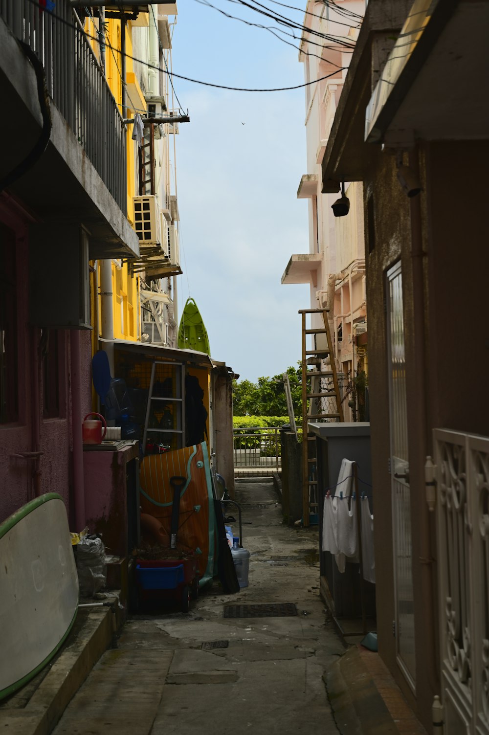 a narrow alley way with a surfboard and other items