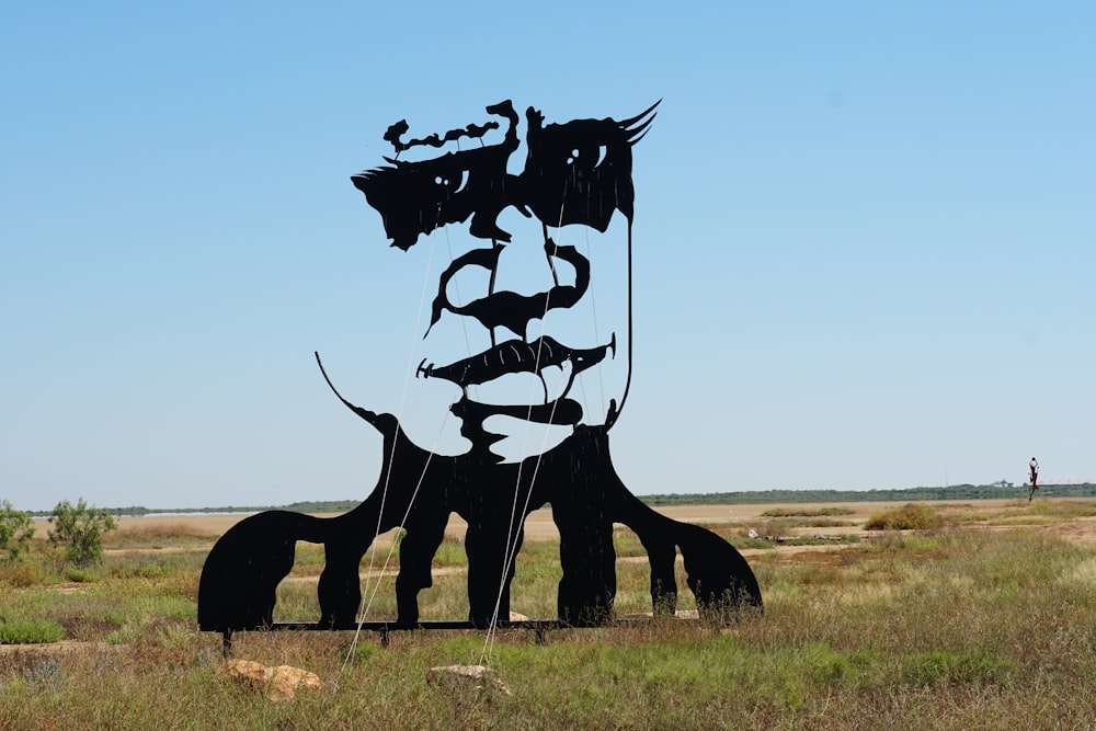a large metal sculpture of a man's face in the middle of a field