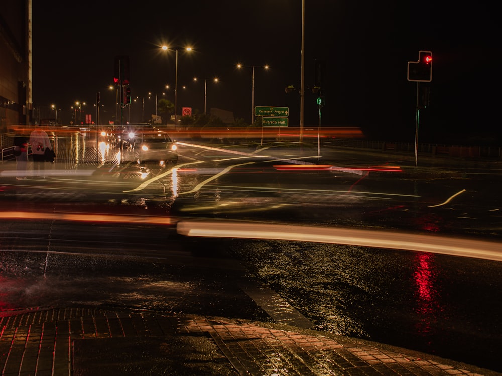 a wet city street at night with a red traffic light