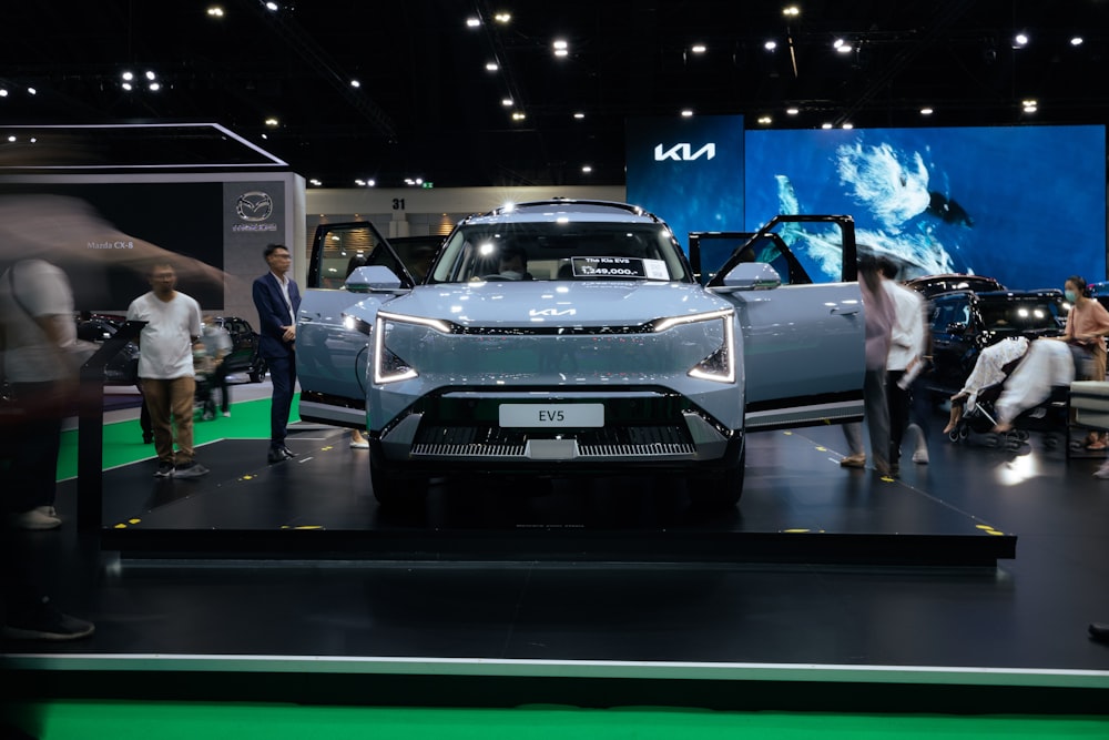 a group of people standing around a car on display