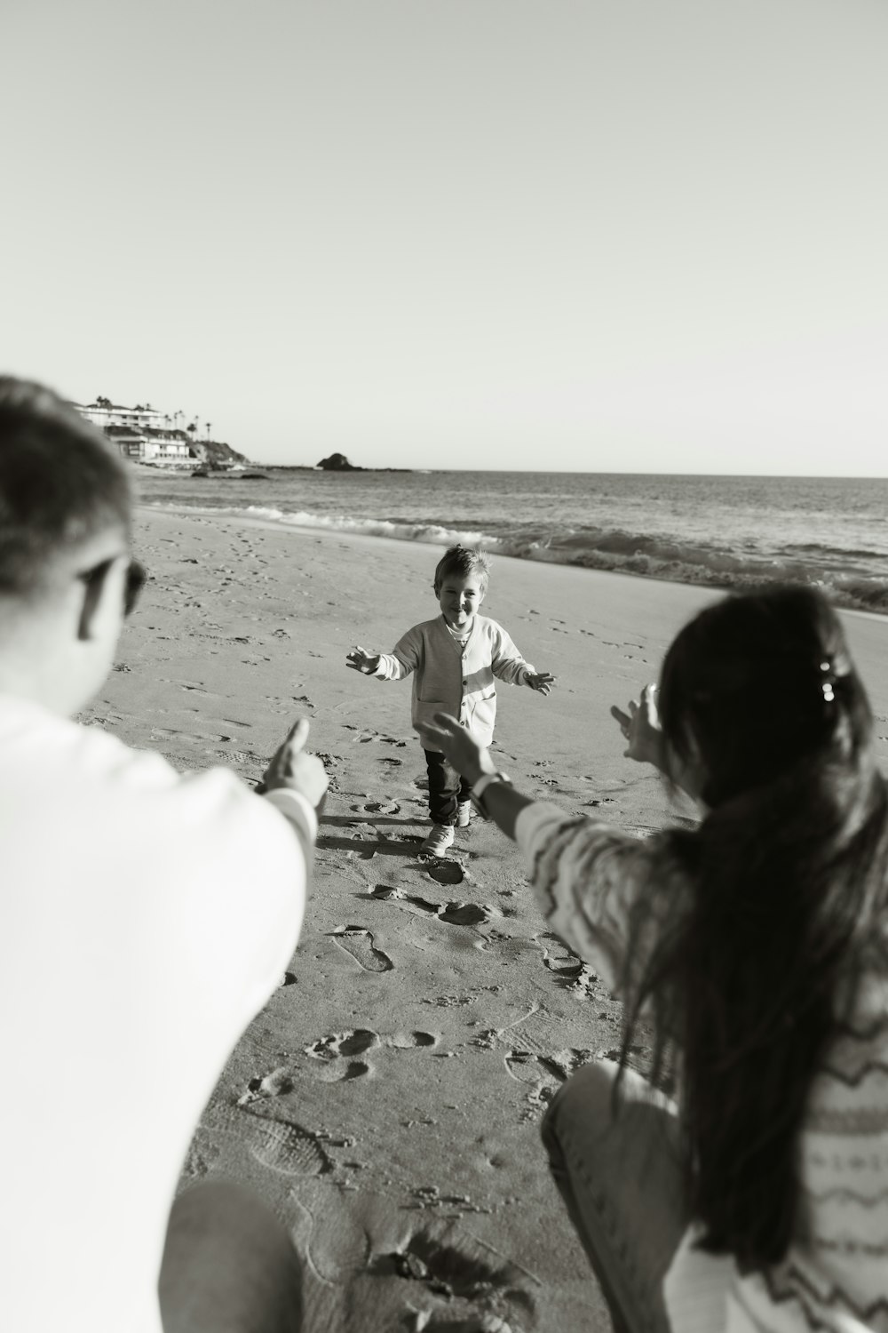 a group of people standing on top of a sandy beach