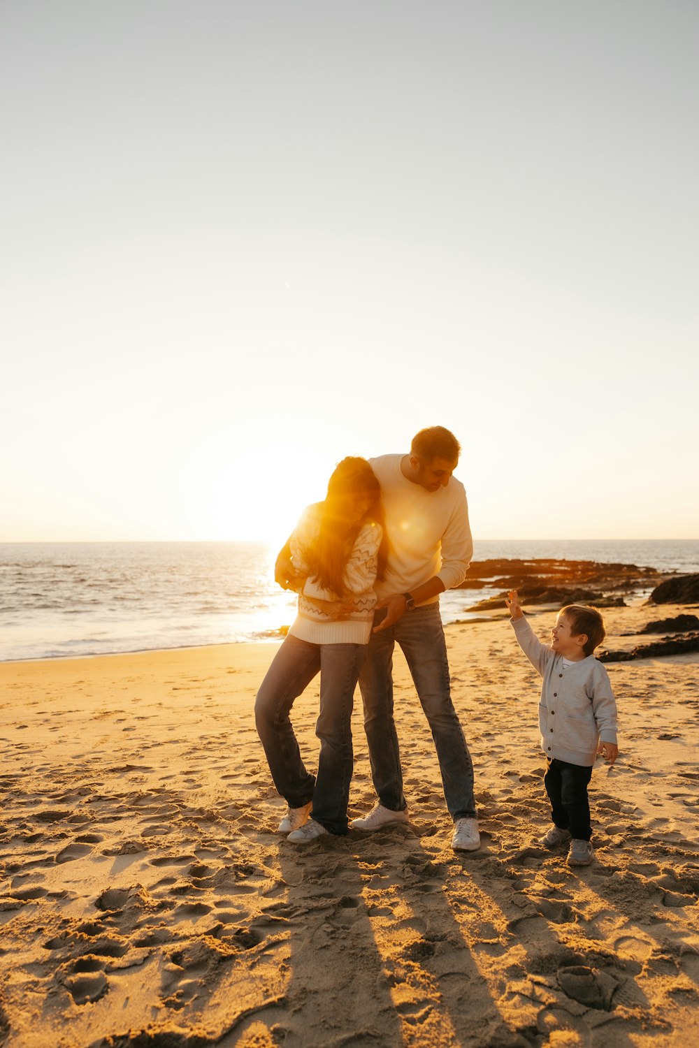 a man and a woman on a beach with a child