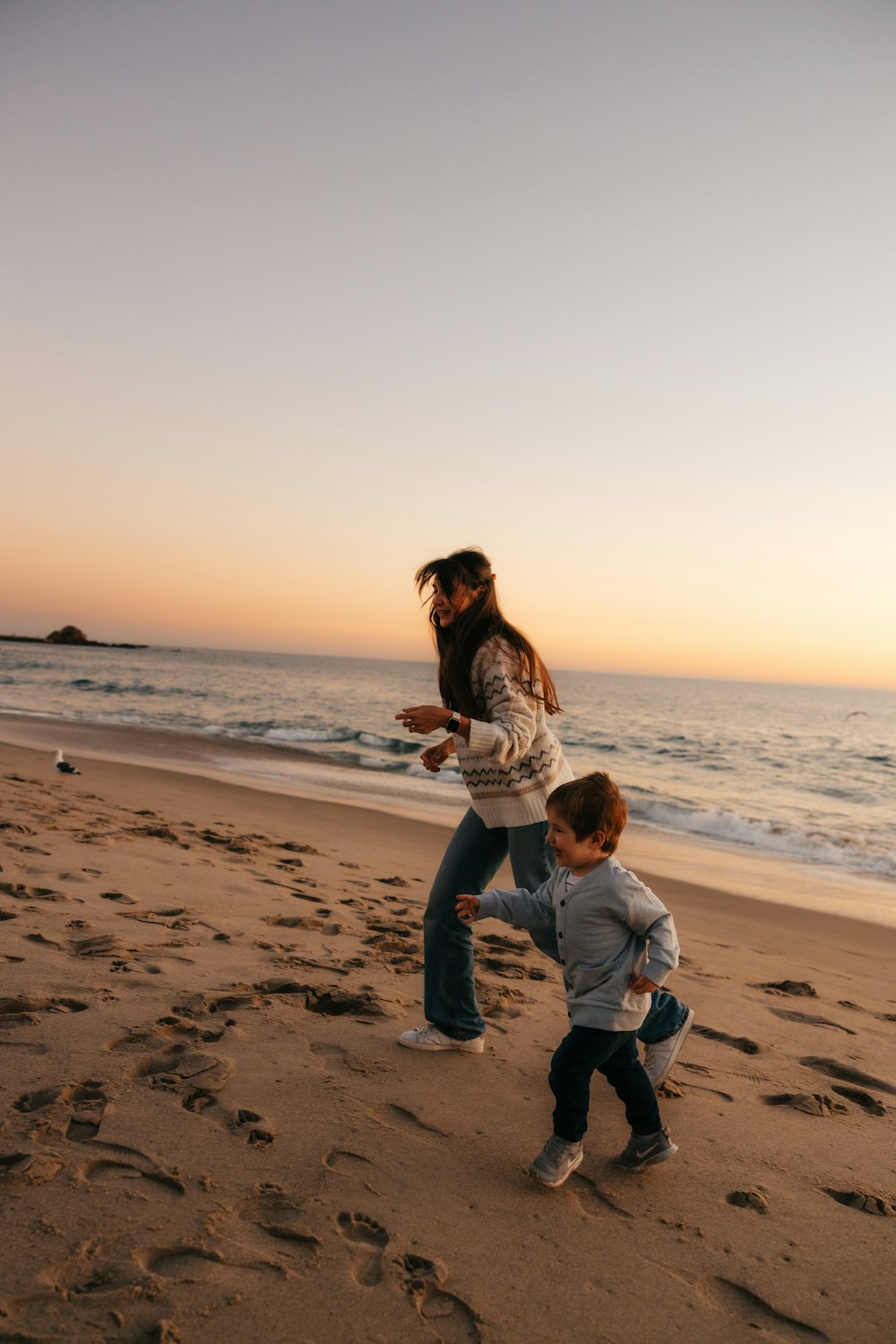 una donna e un bambino che giocano sulla spiaggia
