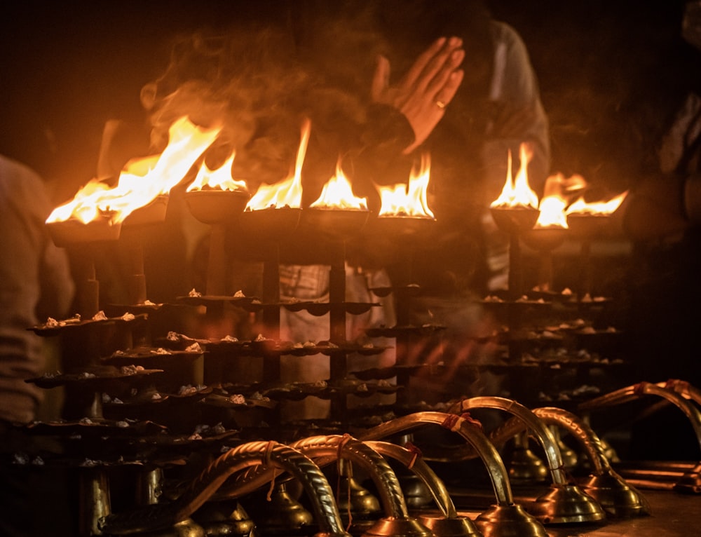 una persona in piedi di fronte a un mucchio di fuoco