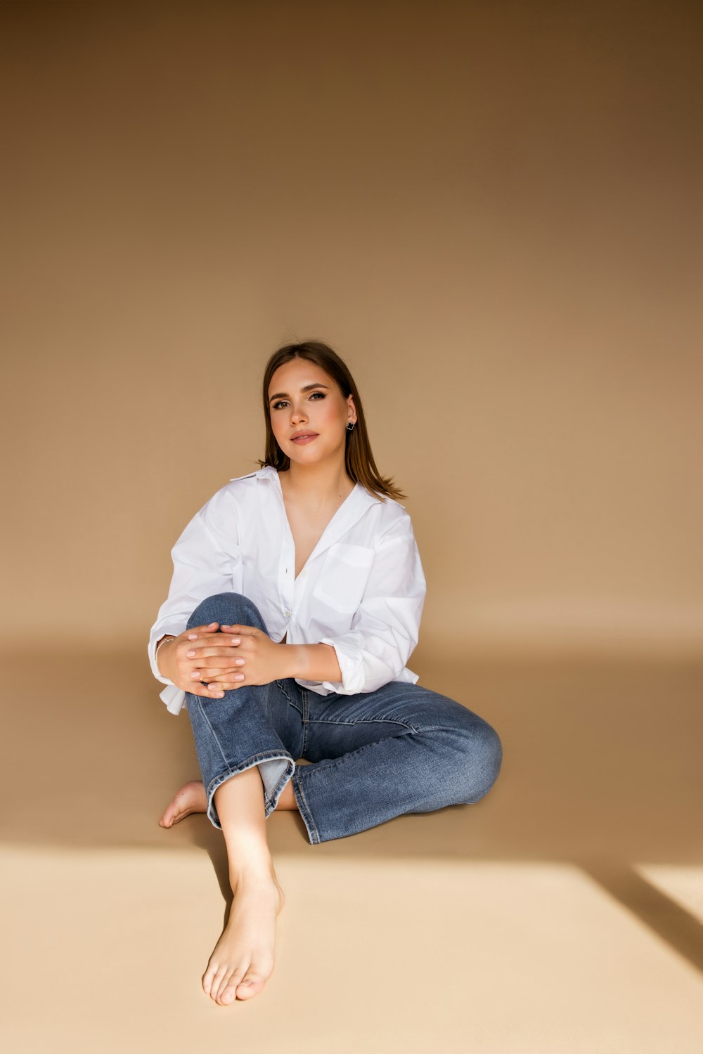 a woman sitting on the ground with her legs crossed