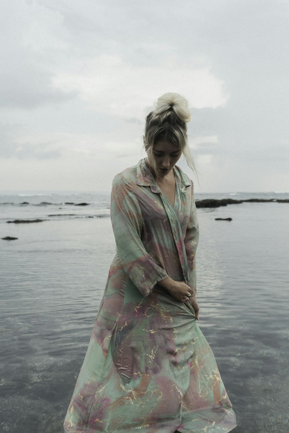 a woman standing on a beach next to the ocean