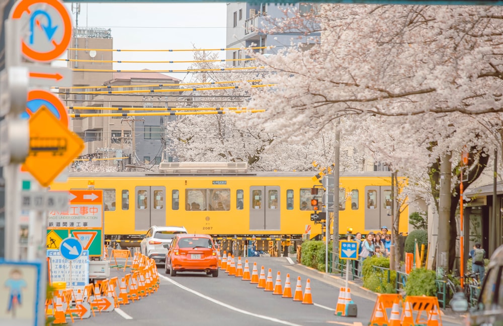 a yellow train traveling down train tracks next to trees