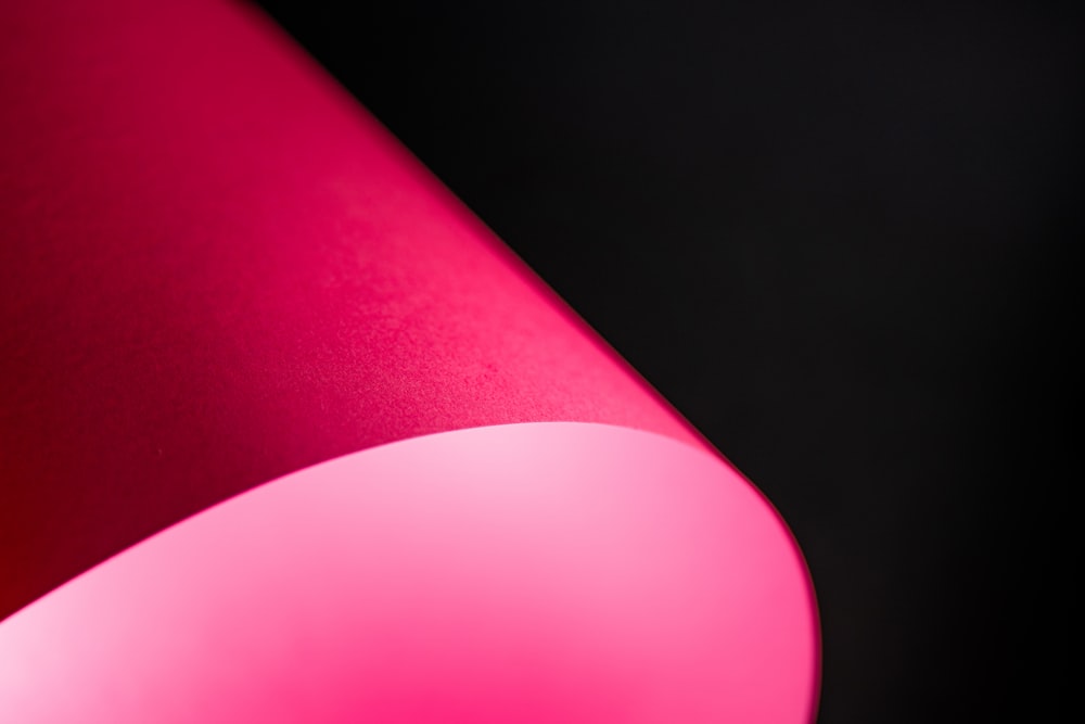 a close up of a pink lamp on a black background