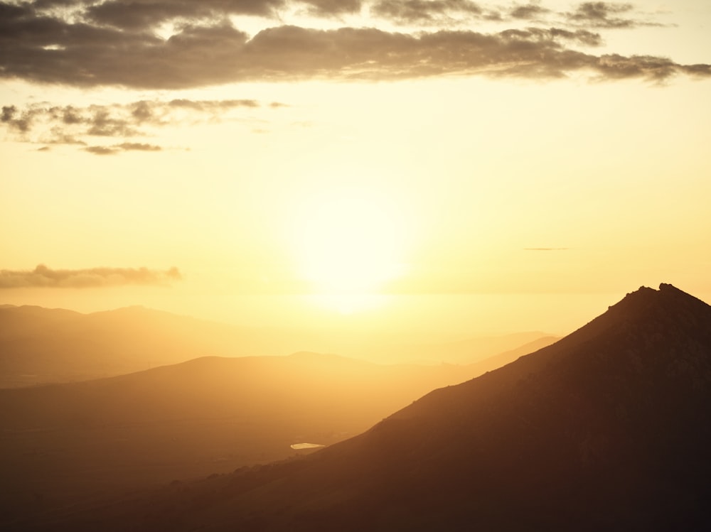 the sun is setting over a mountain range