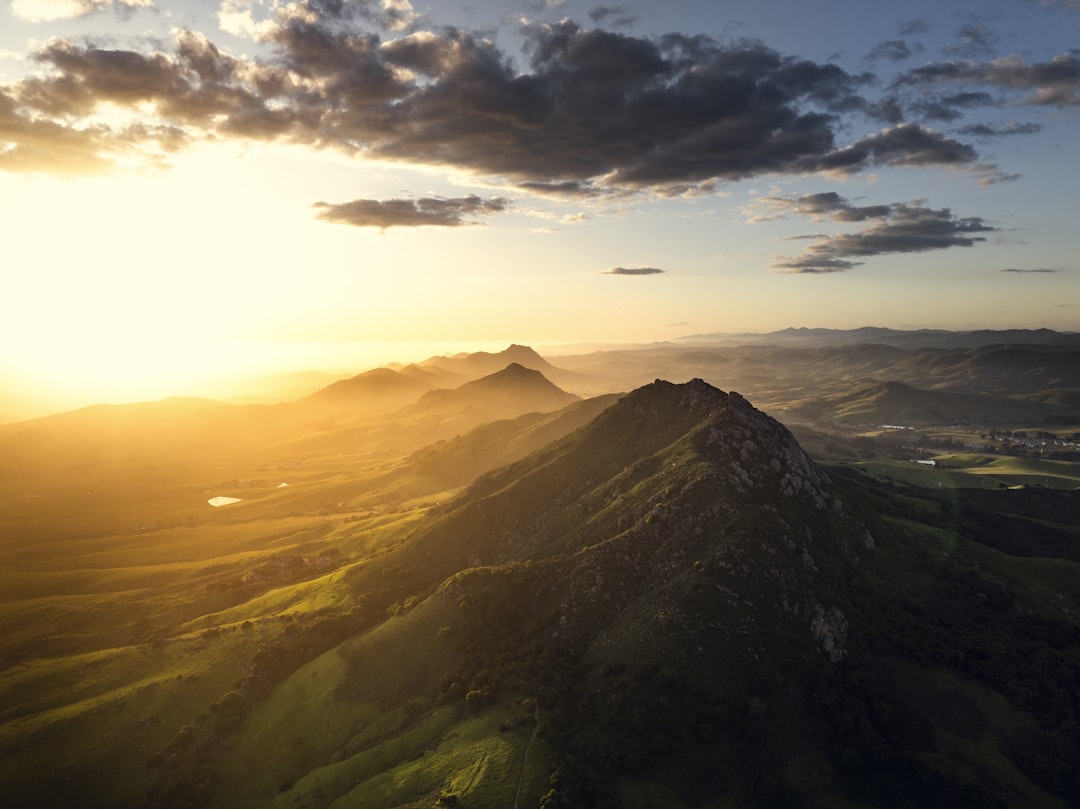 the sun is setting over a mountain range,
