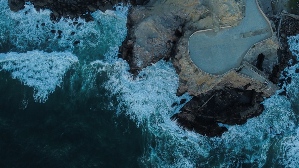 an aerial view of a body of water next to a cliff