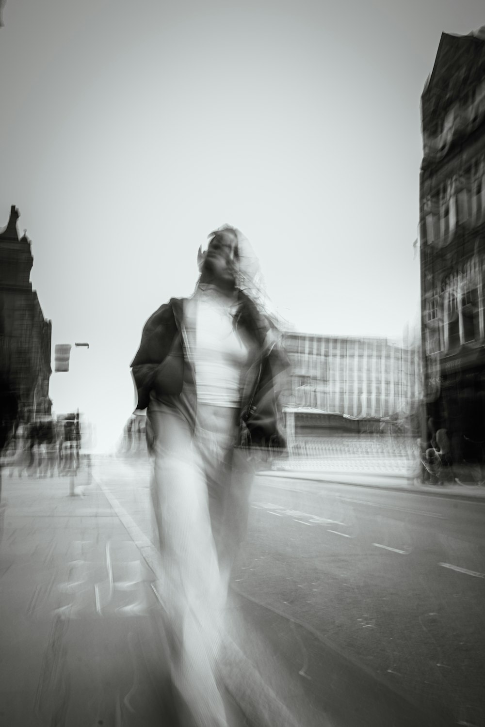 a man riding a skateboard down a street next to tall buildings