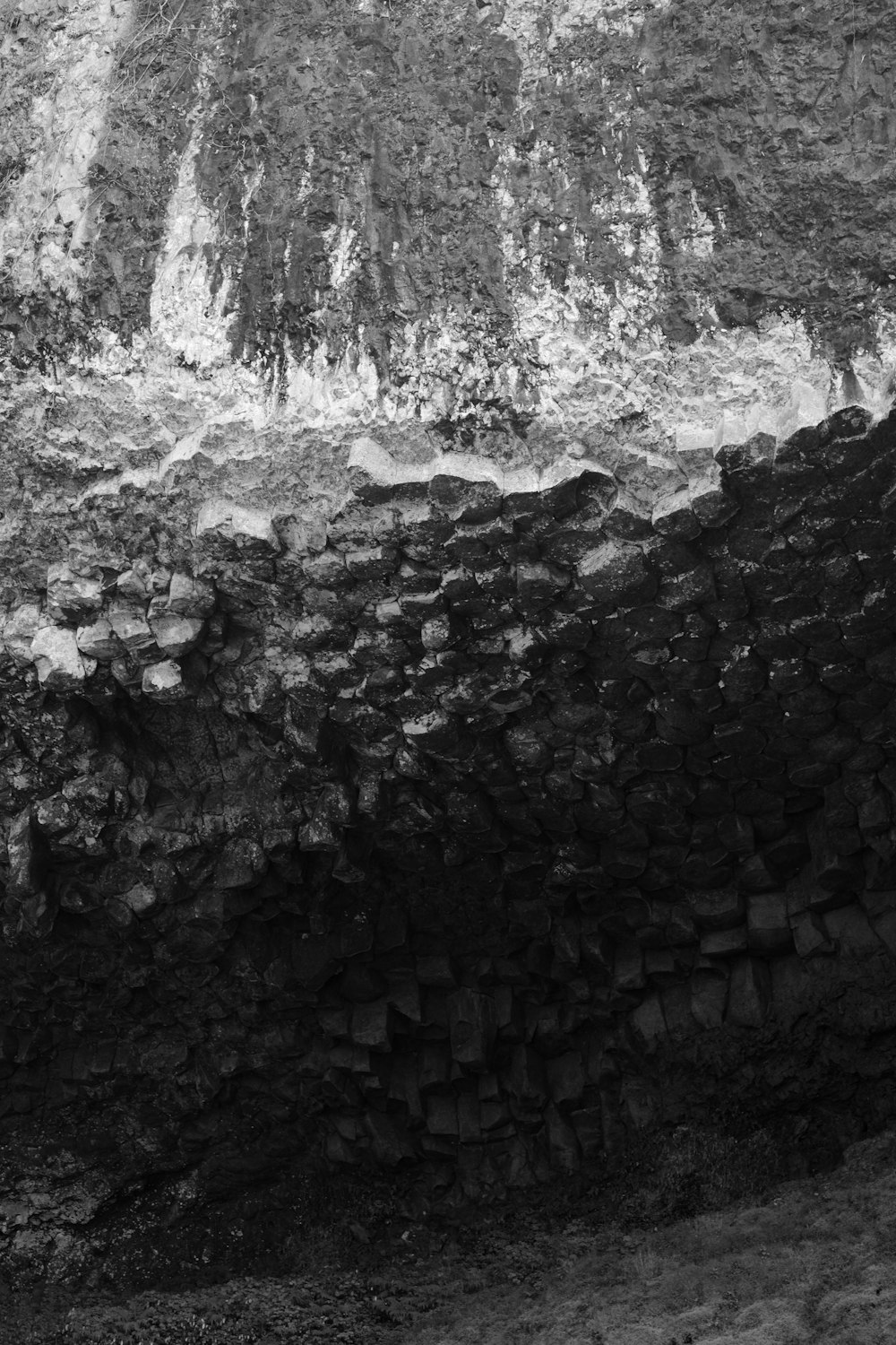 a black and white photo of a stone wall