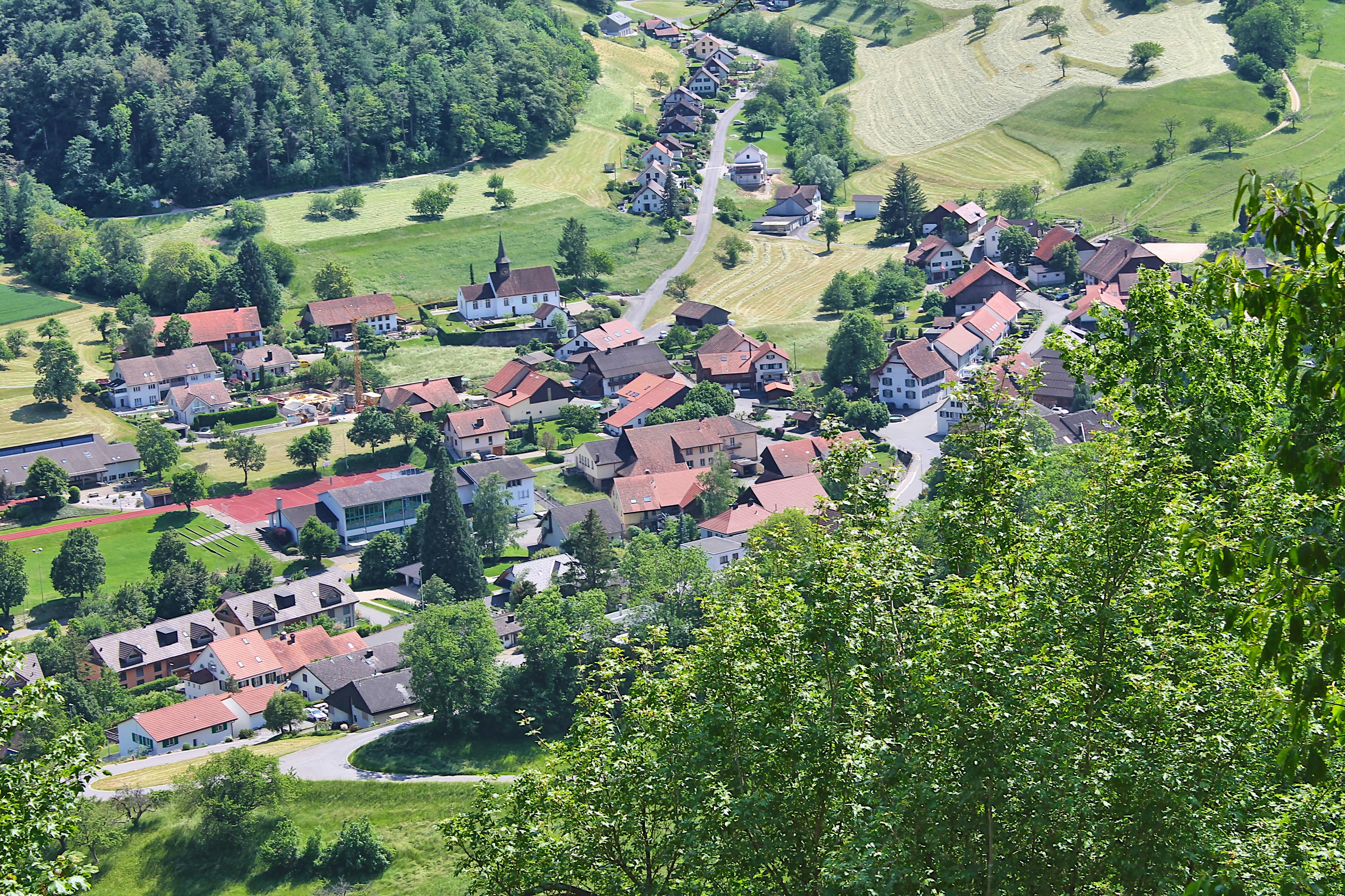 a village nestled in a valley surrounded by trees