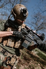 a man in camouflage holding a machine gun