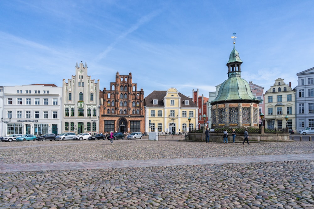 a group of people walking around a cobblestone area