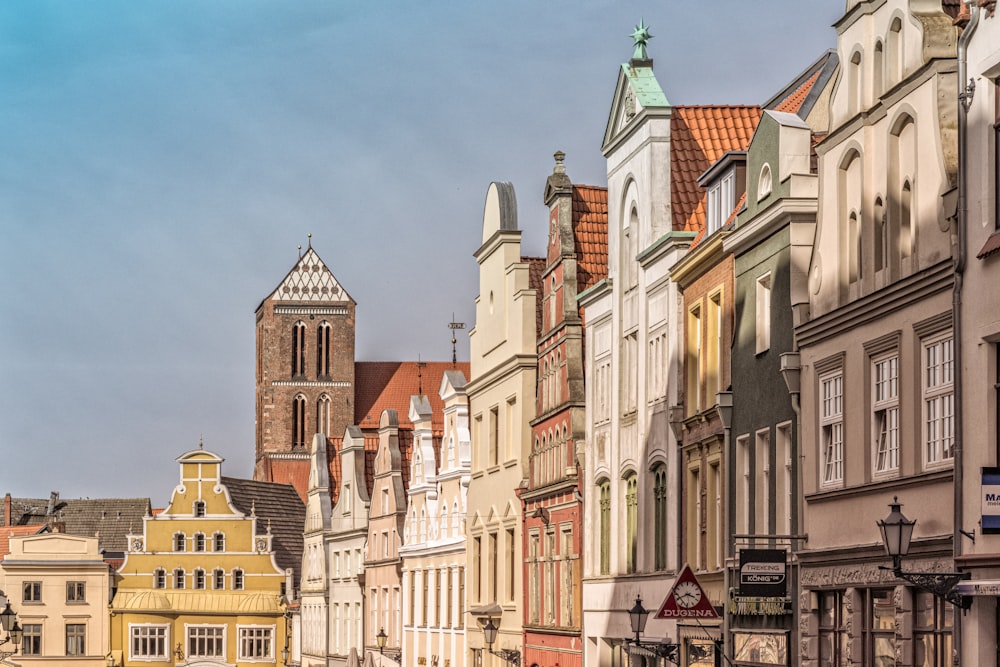 a row of buildings with a clock tower in the background