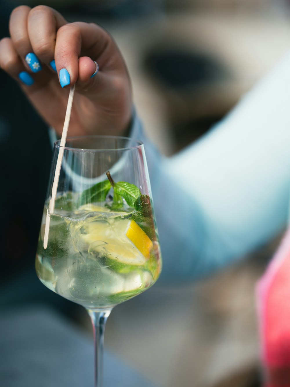 a close up of a person holding a drink in a glass