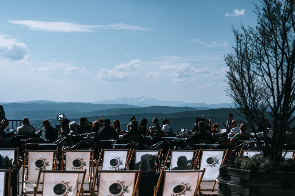 a group of people sitting on top of wooden chairs