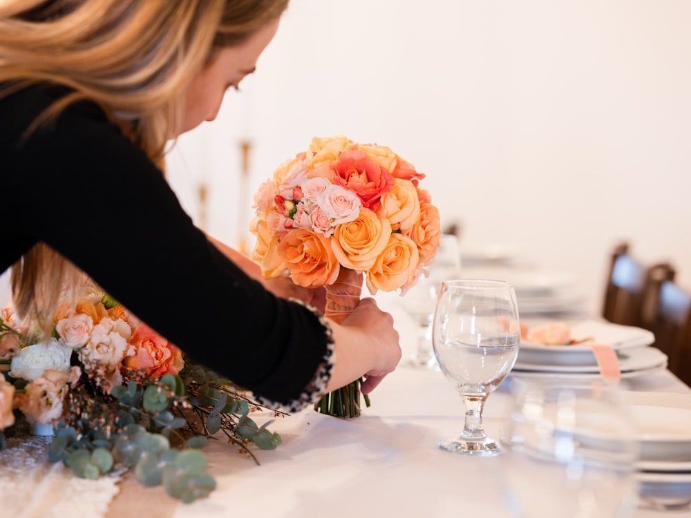 a woman holding a bouquet of flowers at a table