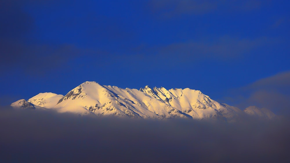 a mountain covered in snow under a blue sky