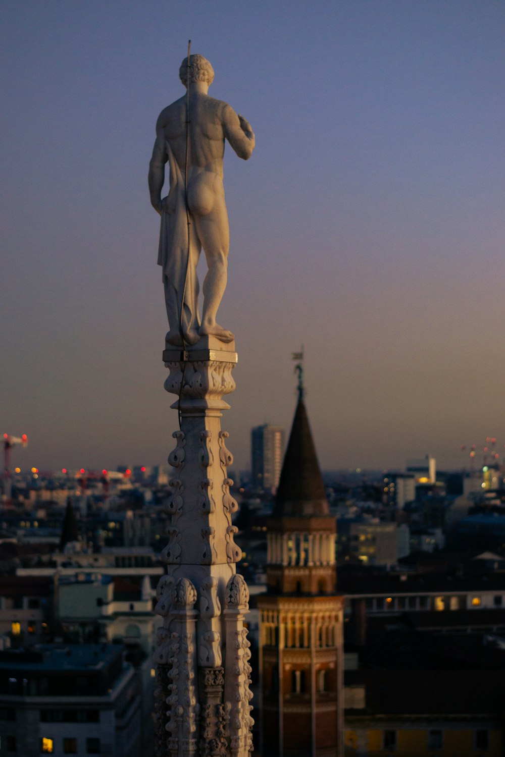 a statue on top of a building with a city in the background