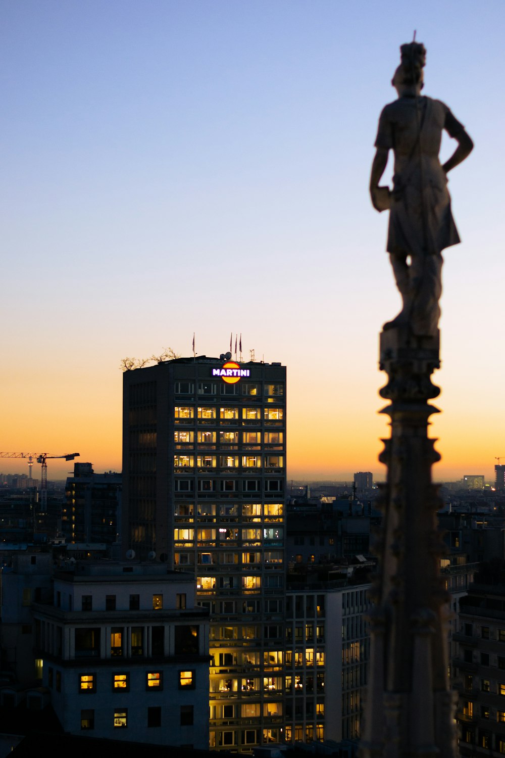 a statue of a man standing on top of a tall building