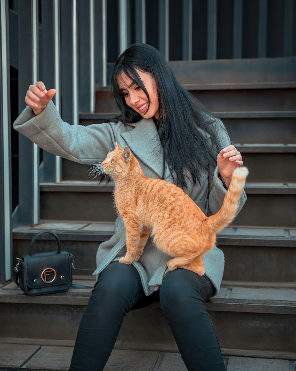 a woman sitting on steps holding a cat