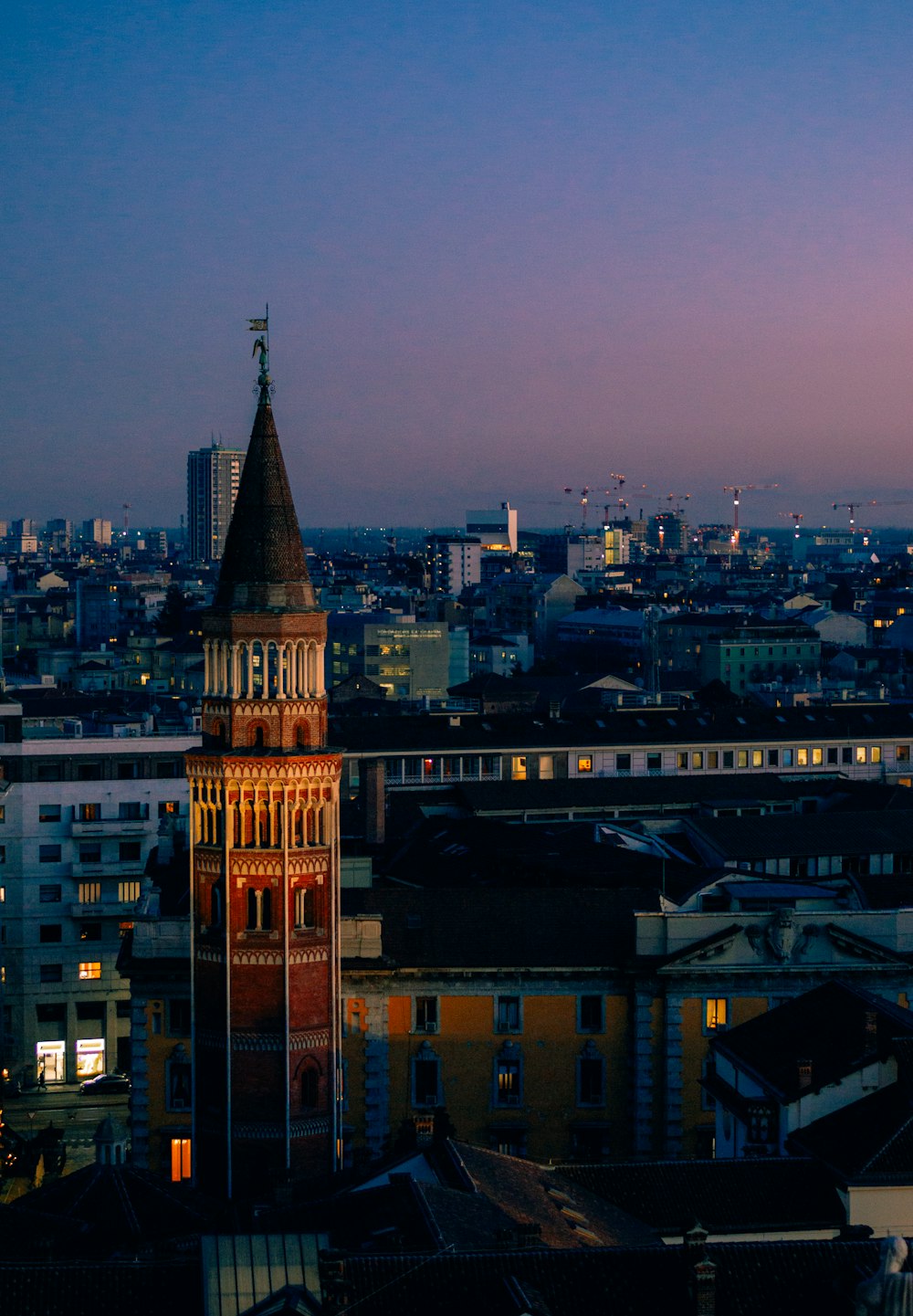 a view of a city at night with a clock tower