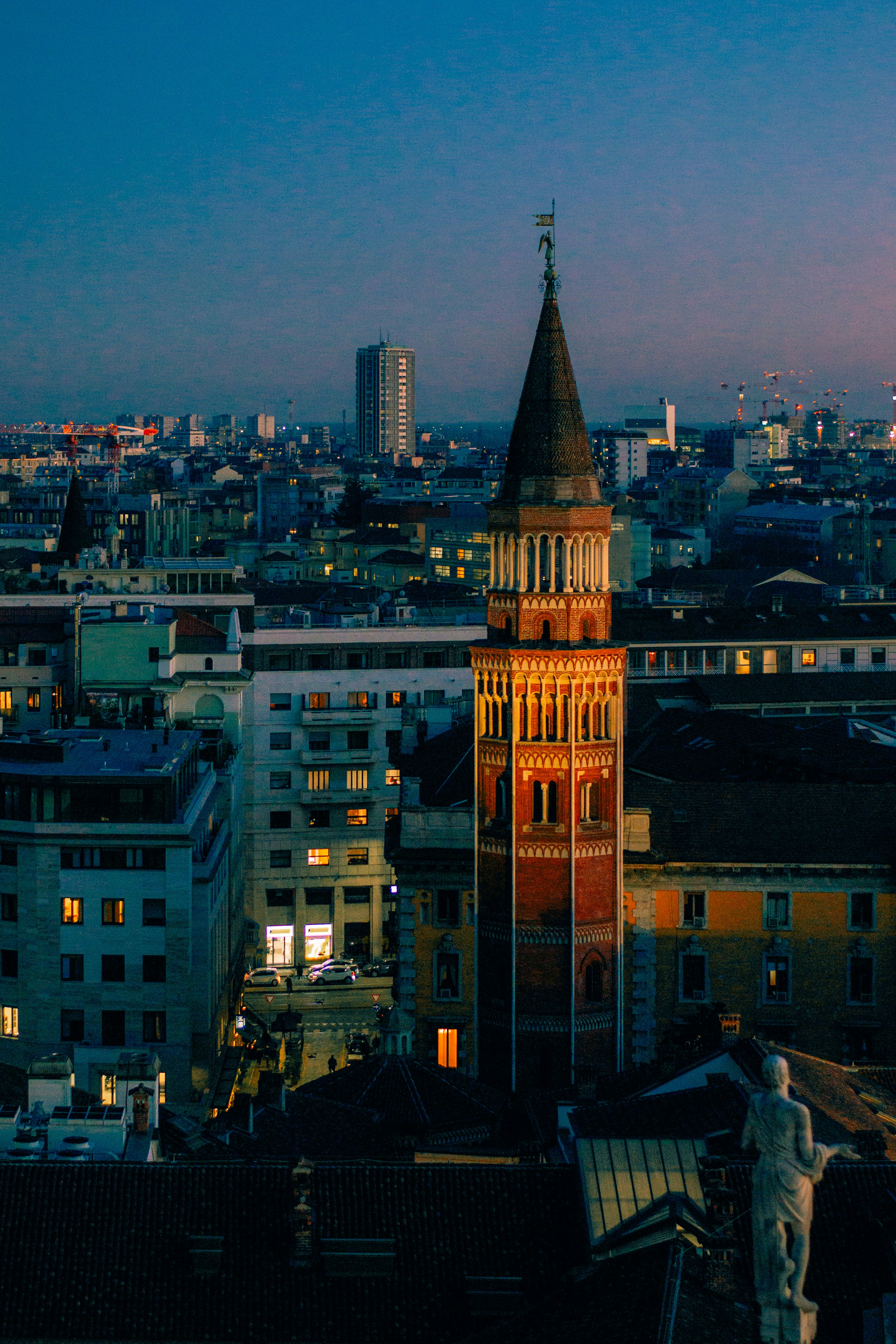 A tall clock tower towering over a city at night photo – Free Milan ...
