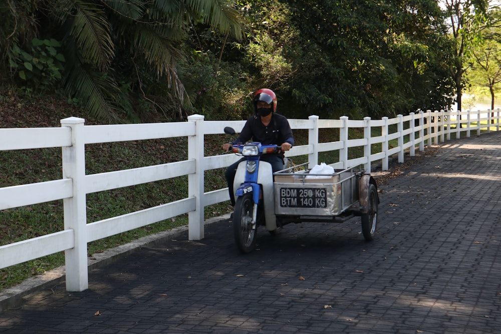 a man riding a motorcycle with a trailer attached to it