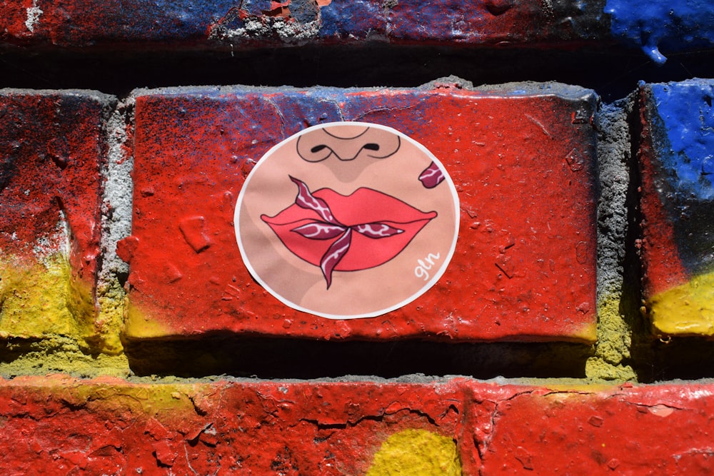 a sticker of a woman's lips on a brick wall