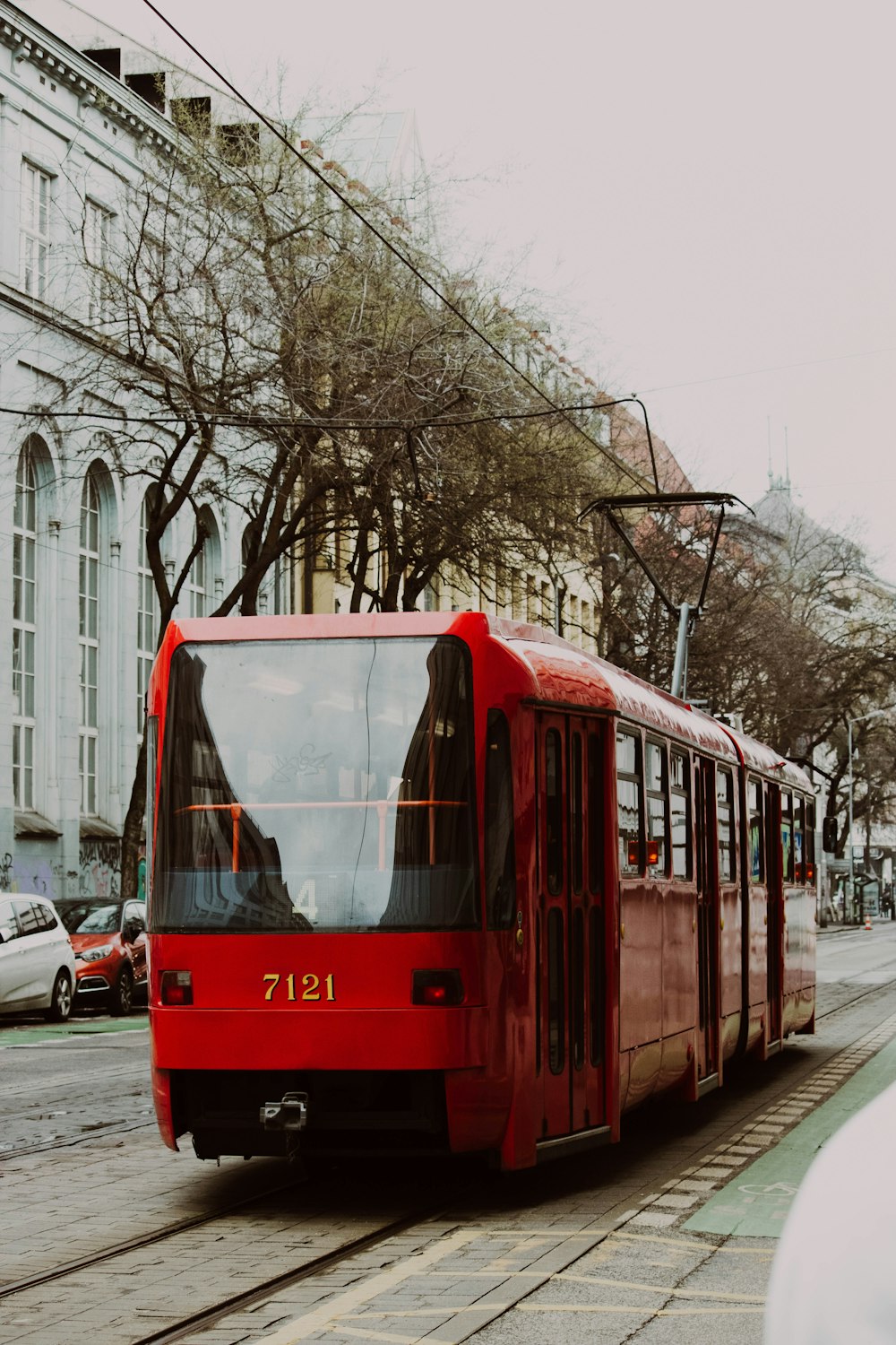 a red trolley car on a city street