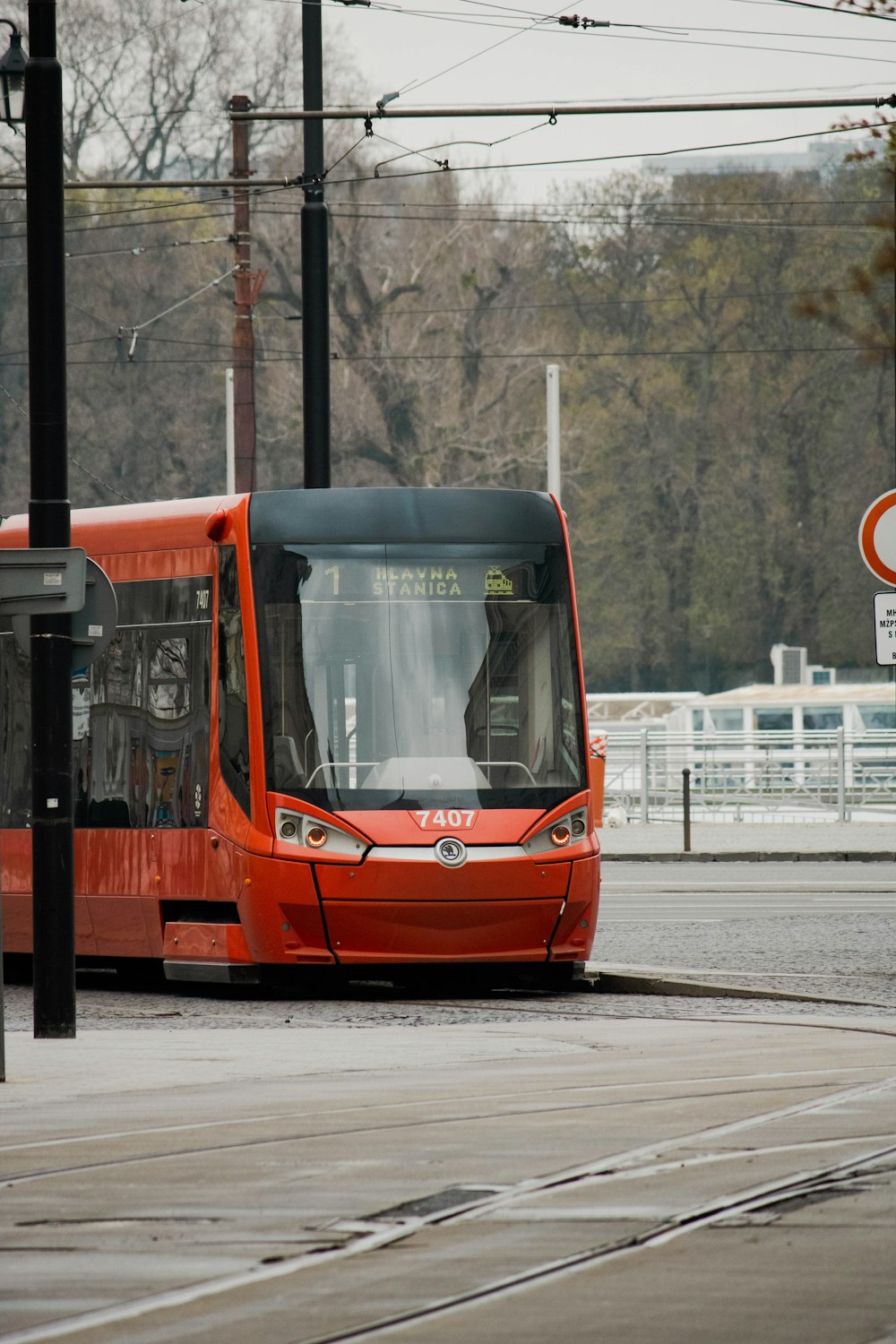 a red bus driving down a street next to a traffic light