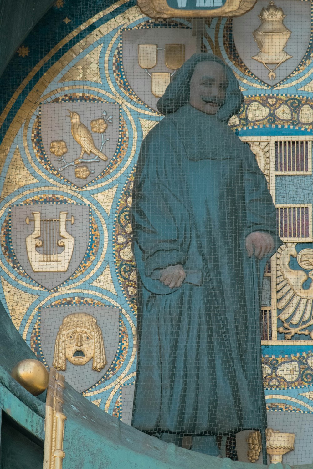 a statue of a person standing in front of a stained glass window