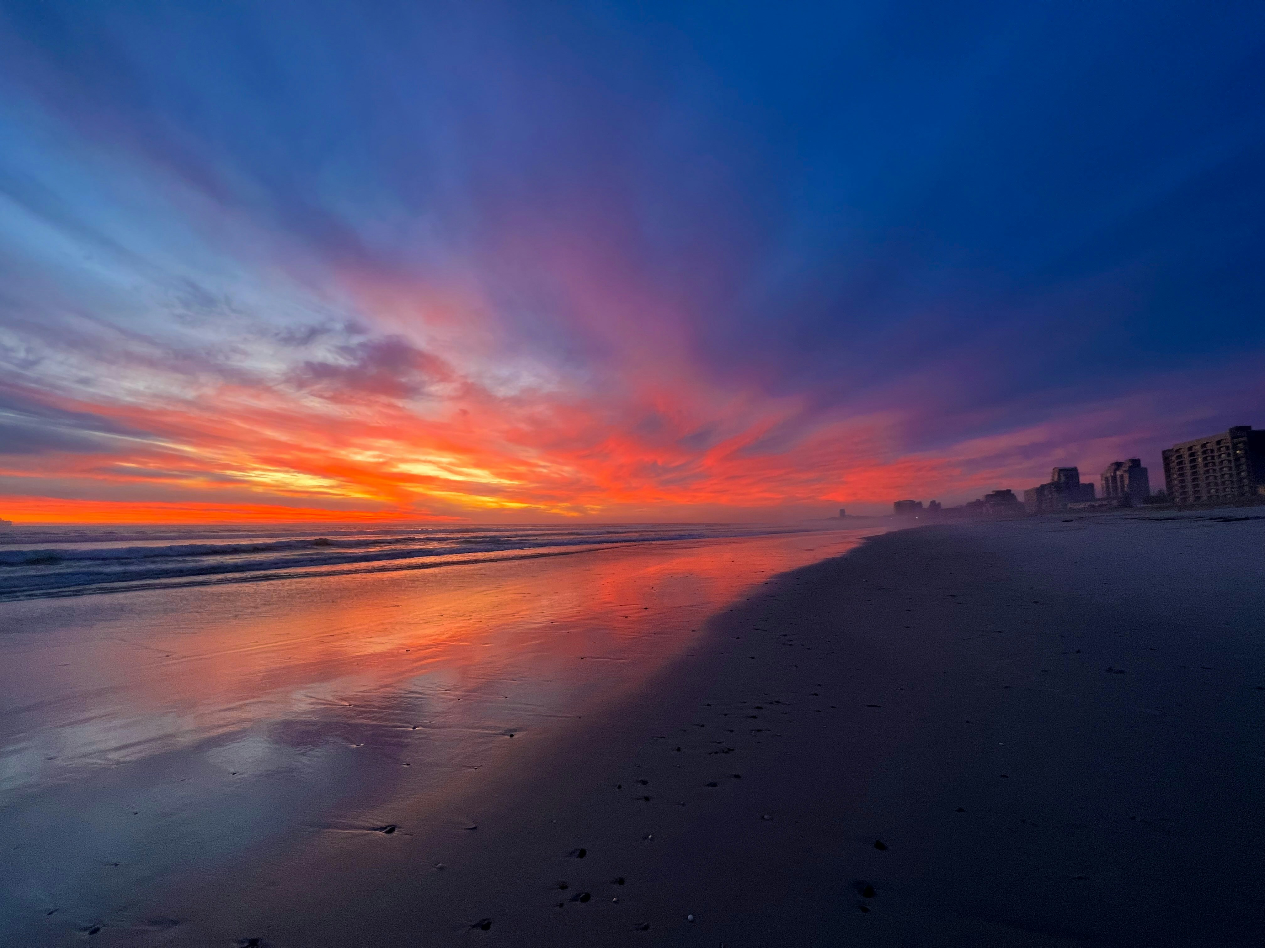 Perfect tropical beach at golden hour with calm water and dramatic sky colors
