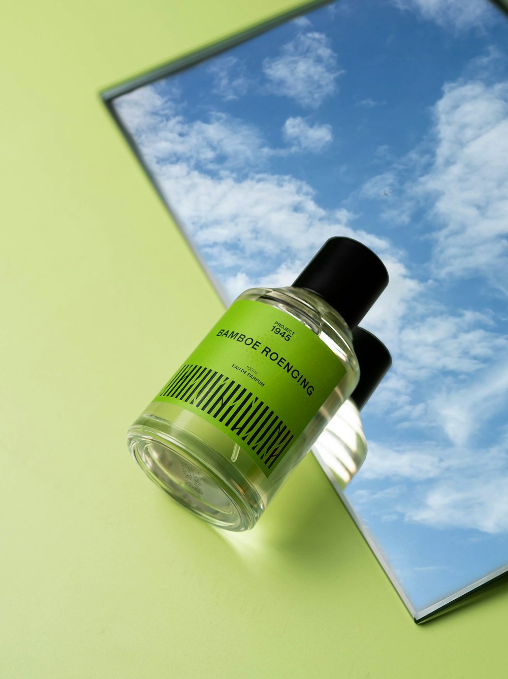 a bottle of green liquid sitting on top of a mirror
