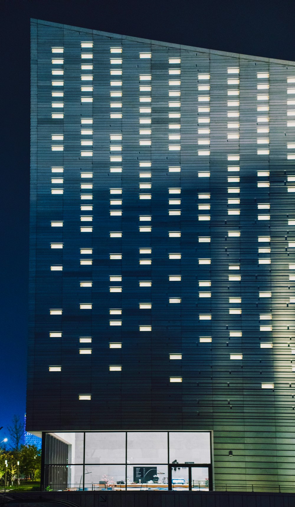 a tall building with lots of windows lit up at night