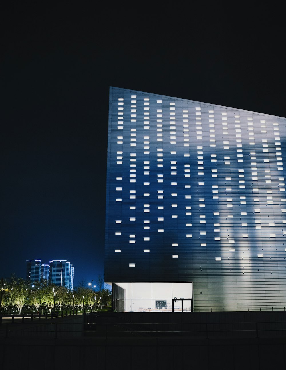 a tall building with a lot of windows lit up at night