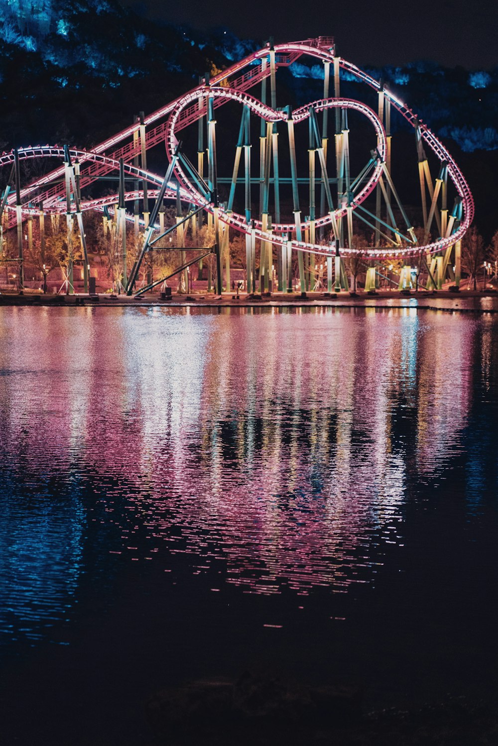 a roller coaster is lit up at night