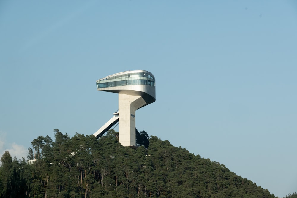 a very tall tower sitting on top of a lush green hillside