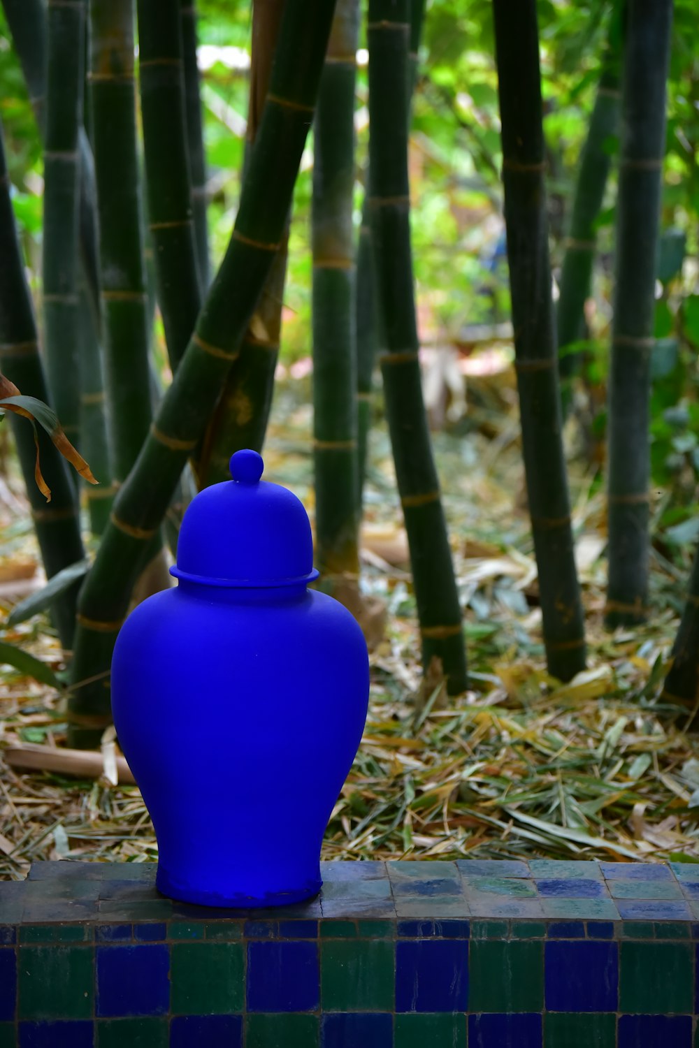 a blue vase sitting on top of a tiled bench