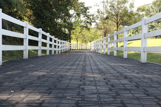 a white fence is on the side of a road